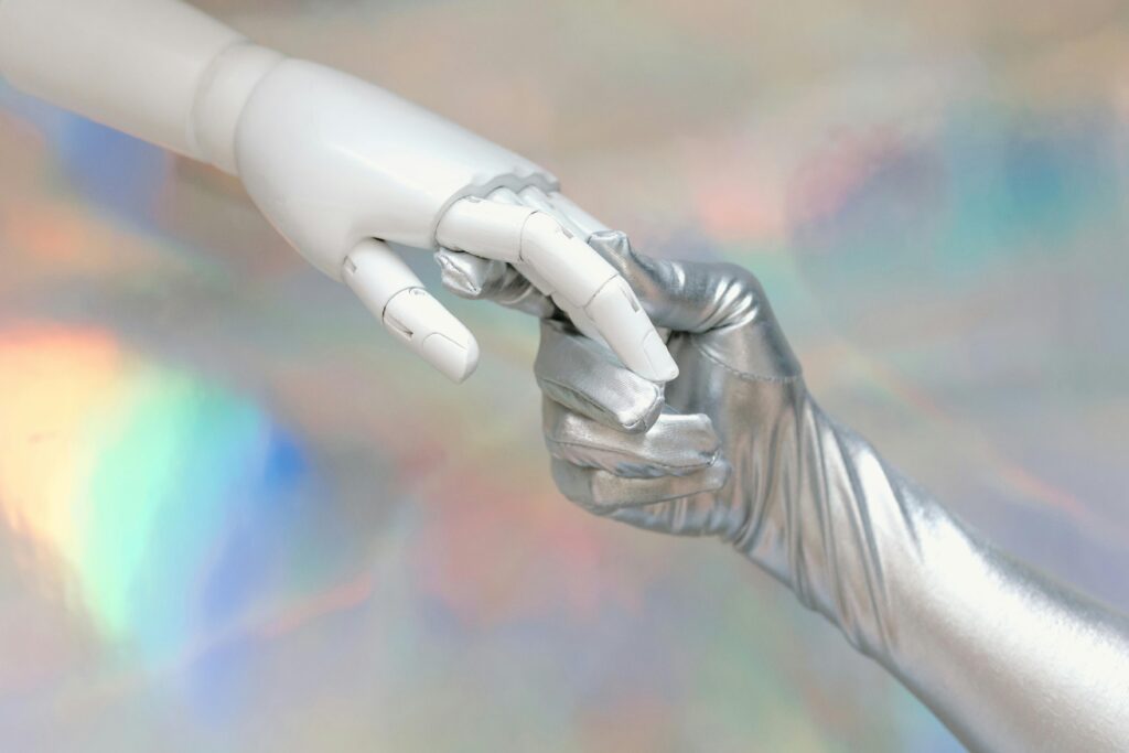Close-up of a robot hand and silver-gloved hand touching, symbolizing human-robot connection.